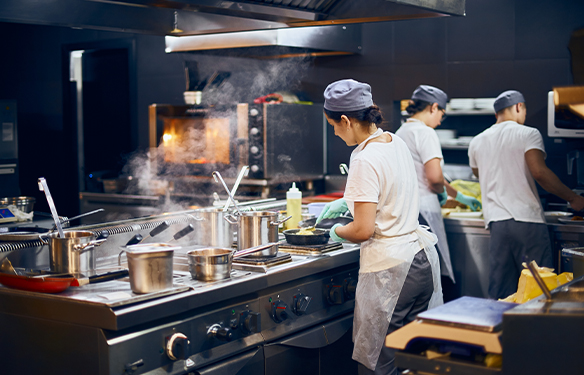 the team of cooks backs in the work in the modern kitchen, the workflow of the restaurant in the kitchen.