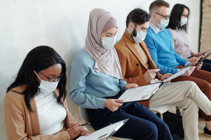 People wearing covid masks waiting for interview